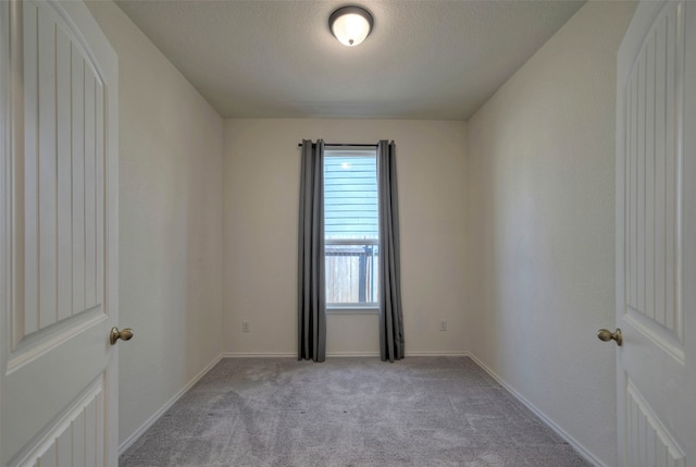 empty room with light carpet, a textured ceiling, and a healthy amount of sunlight