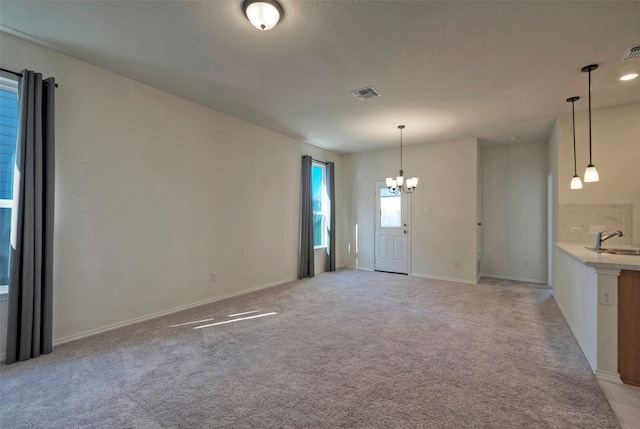 interior space featuring an inviting chandelier, sink, and light colored carpet