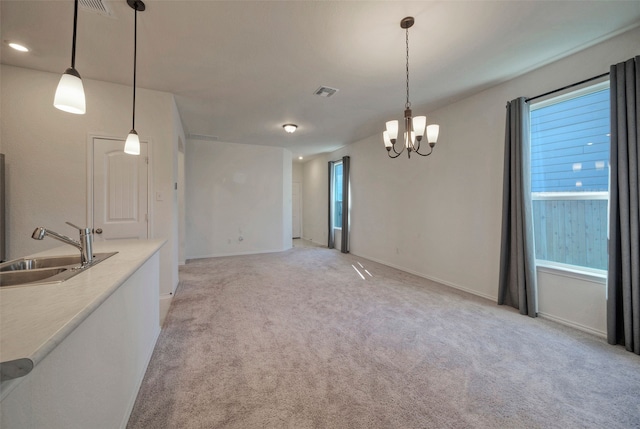 interior space with an inviting chandelier, light colored carpet, and sink