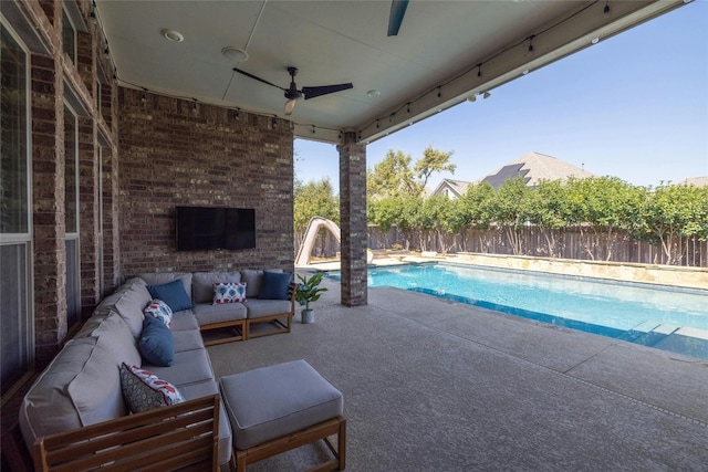 view of swimming pool featuring an outdoor living space with a fireplace, ceiling fan, and a patio area