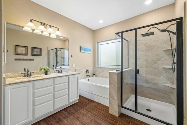 bathroom featuring independent shower and bath, vanity, and hardwood / wood-style floors