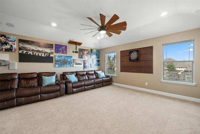 carpeted home theater room with lofted ceiling, a wealth of natural light, and ceiling fan