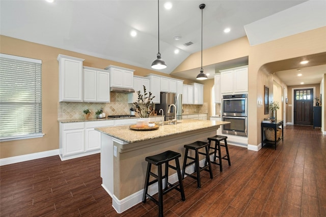 kitchen featuring light stone counters, white cabinets, an island with sink, lofted ceiling, and dark hardwood / wood-style floors