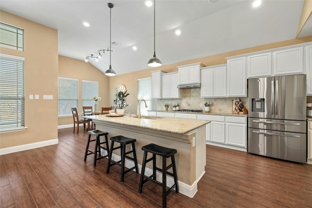 kitchen with stainless steel appliances, an island with sink, and white cabinets