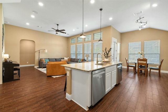 kitchen with light stone counters, stainless steel dishwasher, a kitchen island with sink, dark wood-type flooring, and white cabinetry