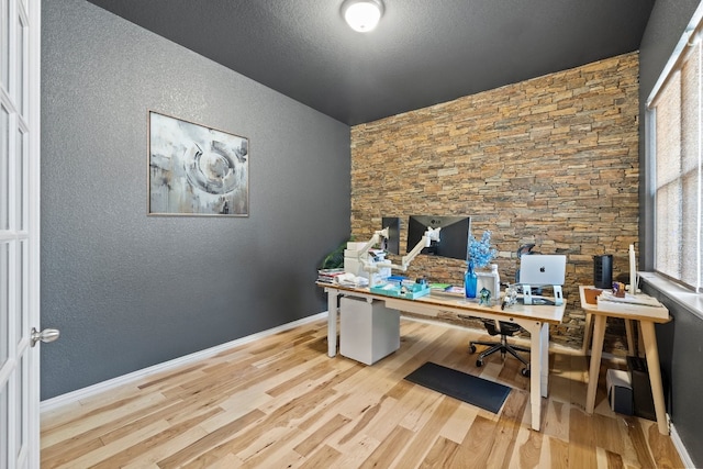 office space featuring a textured ceiling and light wood-type flooring