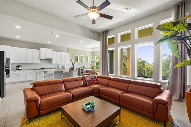 tiled living room featuring a wealth of natural light and ceiling fan