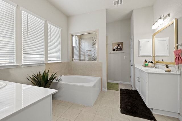 bathroom featuring tile patterned flooring, vanity, and a tub to relax in