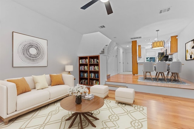 living room featuring light wood-type flooring and ceiling fan