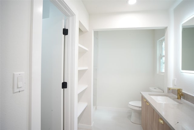 bathroom featuring tile patterned floors, vanity, and toilet