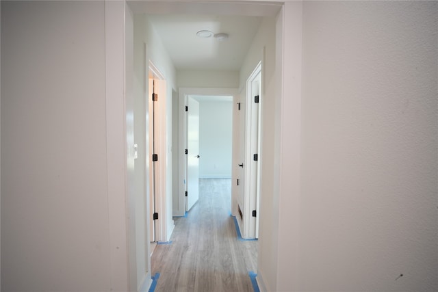 hallway with light hardwood / wood-style floors