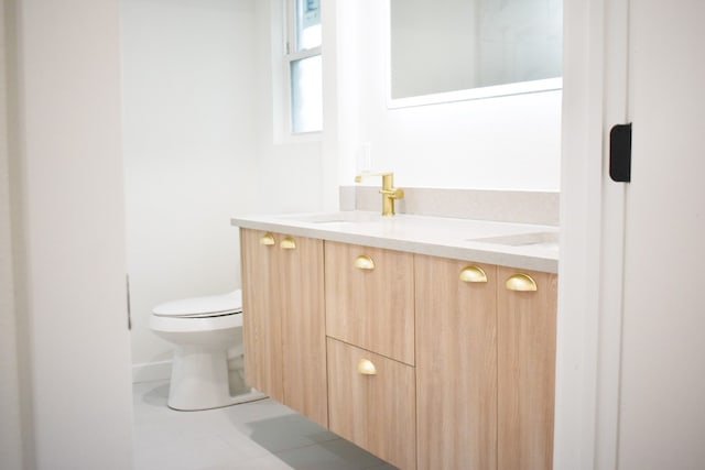 bathroom with tile patterned floors, vanity, and toilet