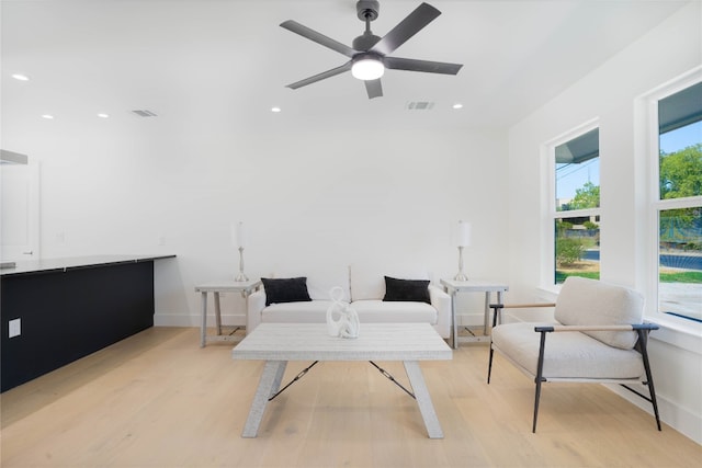 living area with ceiling fan, a healthy amount of sunlight, and light hardwood / wood-style flooring