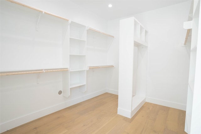 walk in closet with light hardwood / wood-style flooring