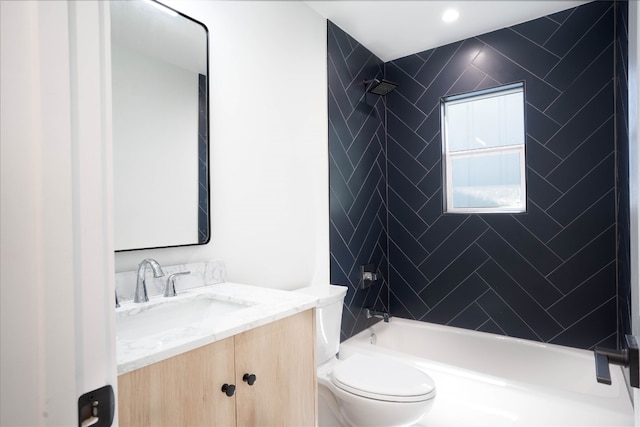 full bathroom featuring vanity, tiled shower / bath combo, and toilet