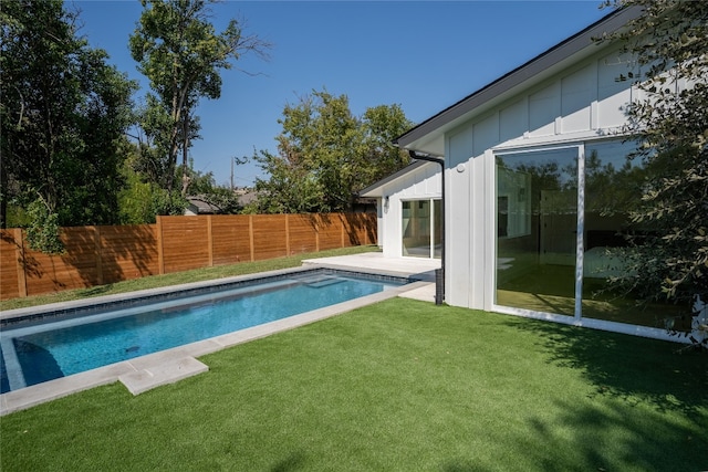 view of swimming pool featuring a yard