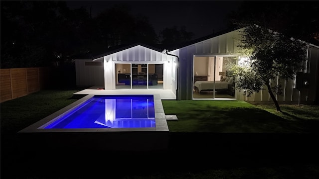 back house at twilight featuring a lawn