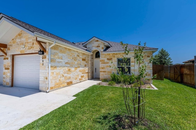 ranch-style house with a garage and a front lawn