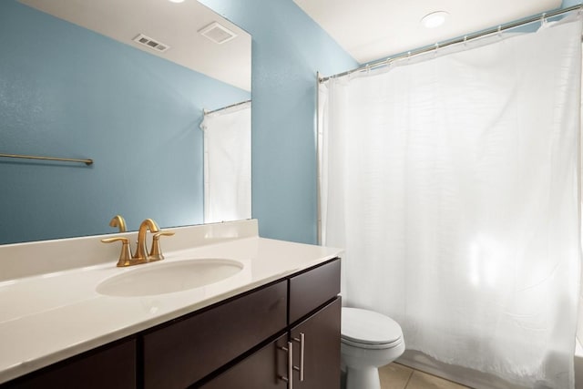 bathroom featuring tile patterned floors, vanity, toilet, and walk in shower