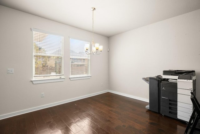 unfurnished office with dark wood-type flooring and a notable chandelier