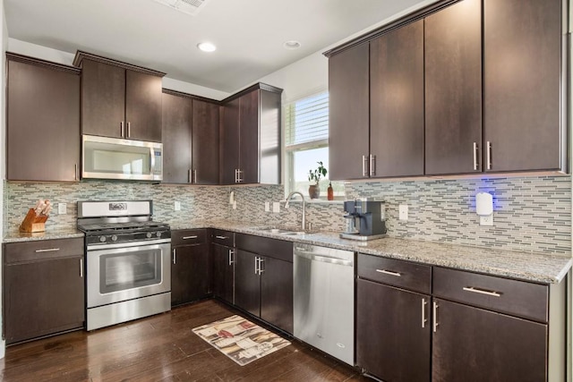 kitchen featuring sink, dark brown cabinetry, stainless steel appliances, and dark wood-type flooring