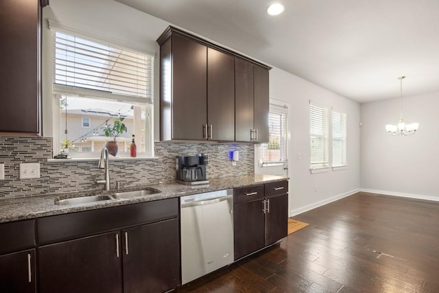 kitchen with light stone counters, stainless steel dishwasher, sink, a chandelier, and dark hardwood / wood-style floors