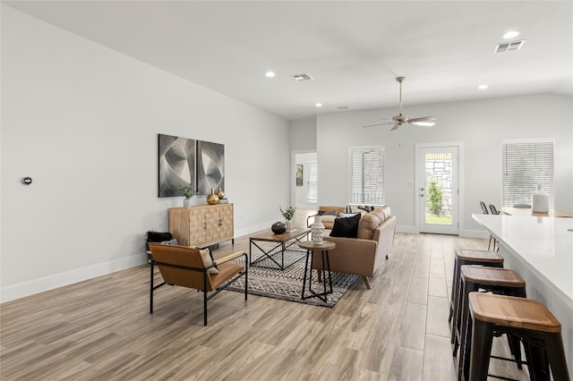 living room featuring vaulted ceiling, light wood-type flooring, and ceiling fan