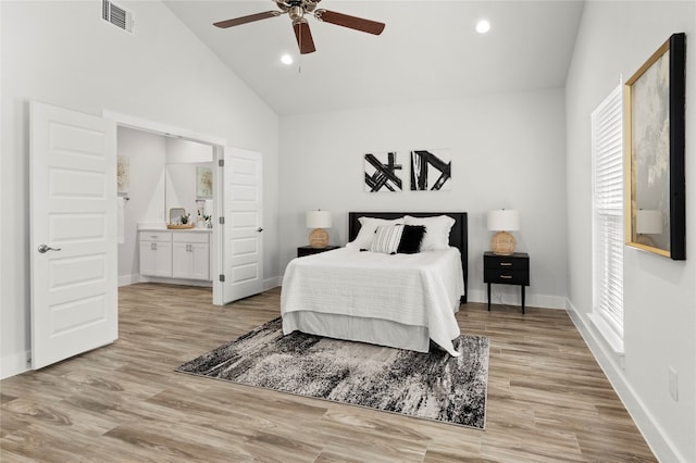 bedroom with high vaulted ceiling, ensuite bath, ceiling fan, and light hardwood / wood-style flooring