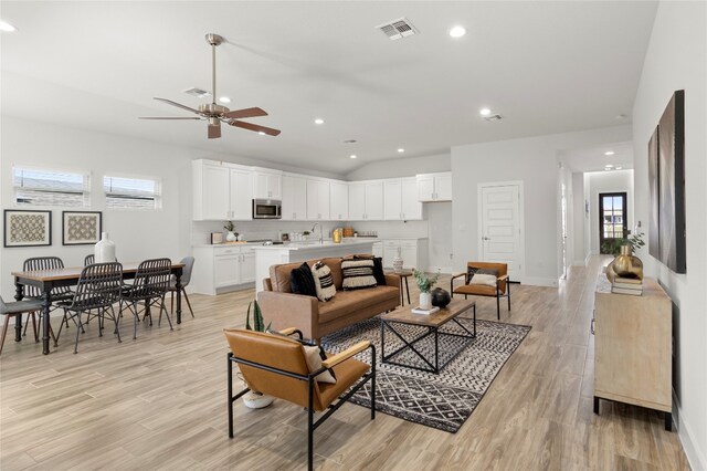 living room with light wood-type flooring and ceiling fan