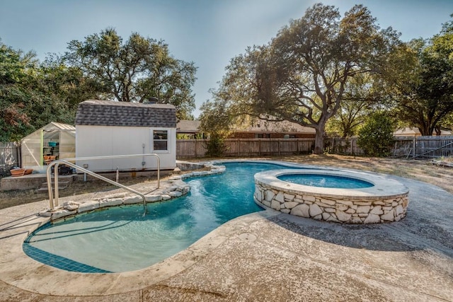 view of swimming pool with an in ground hot tub and a storage unit