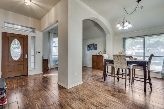 dining room featuring wood-type flooring, an inviting chandelier, and crown molding