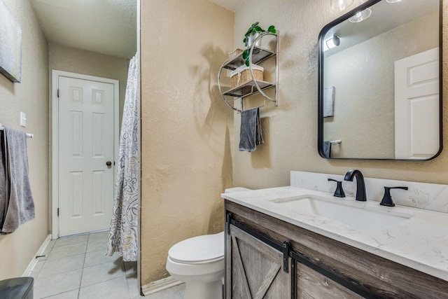 bathroom with tile patterned flooring, vanity, and toilet