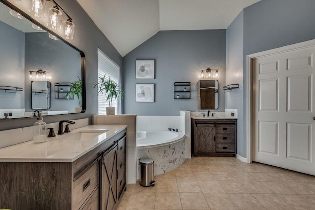 bathroom with tile patterned floors, tiled tub, vanity, and vaulted ceiling