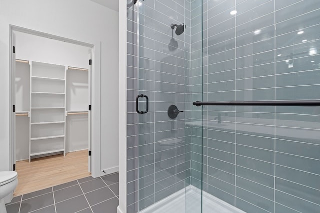 bathroom featuring toilet, hardwood / wood-style floors, and a shower with door