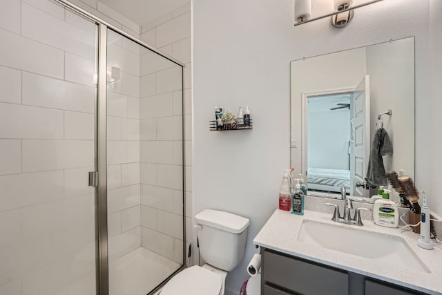 bathroom featuring vanity, a shower with shower door, and toilet