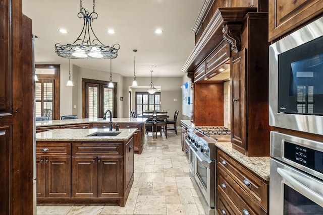 kitchen featuring stone tile flooring, recessed lighting, stainless steel appliances, and a sink