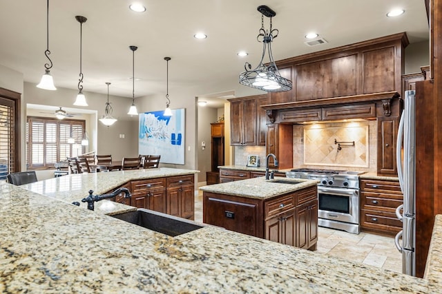 kitchen with visible vents, an island with sink, decorative backsplash, stainless steel appliances, and a sink