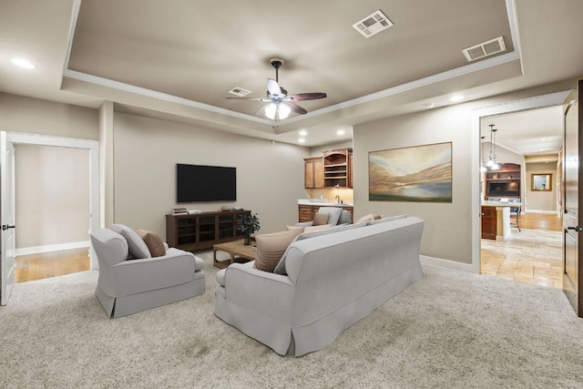 living area featuring visible vents and a raised ceiling