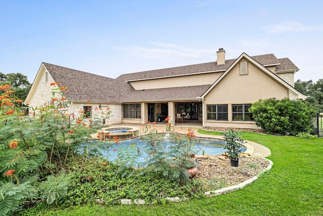 back of property with stucco siding, a lawn, a pool with connected hot tub, a patio, and a chimney