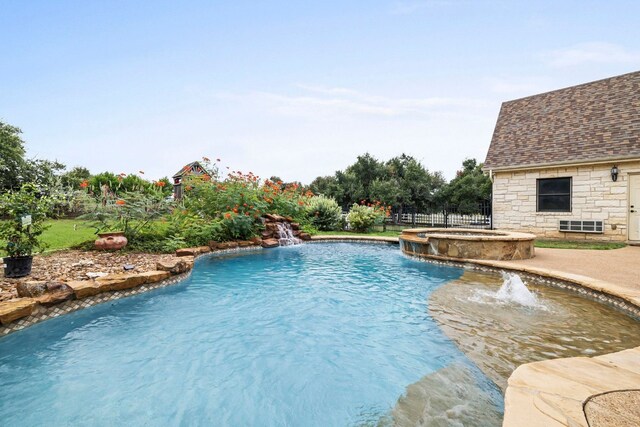 view of pool with a patio area, fence, and a pool with connected hot tub