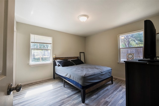 bedroom with hardwood / wood-style flooring and multiple windows