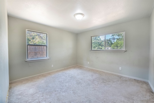 carpeted spare room featuring a textured ceiling