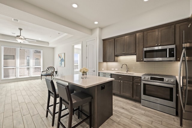 kitchen with stainless steel appliances, a center island, sink, and a healthy amount of sunlight