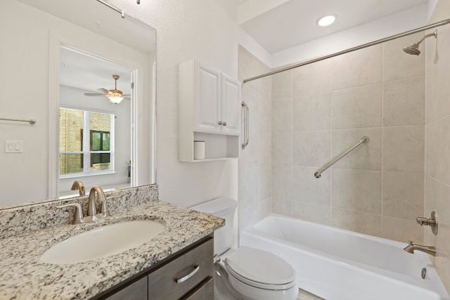 full bathroom with ceiling fan, vanity, toilet, and tiled shower / bath