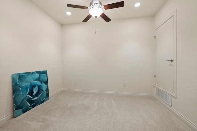 empty room featuring light colored carpet and ceiling fan