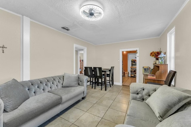 tiled living room featuring ornamental molding and a textured ceiling