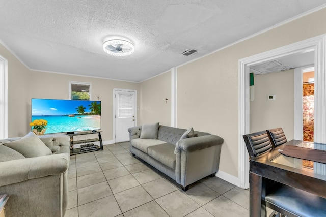 living room featuring crown molding, light tile patterned flooring, and a textured ceiling