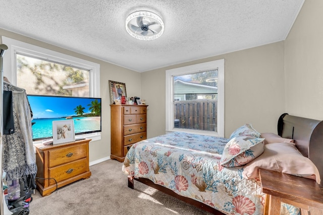 bedroom with a textured ceiling and light colored carpet