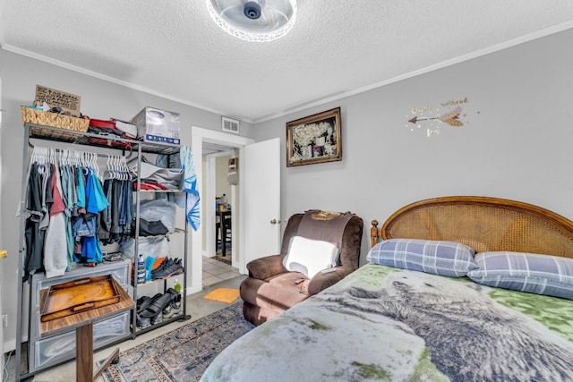 bedroom featuring crown molding, a closet, and a textured ceiling