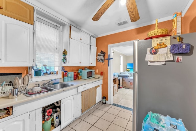 kitchen featuring white cabinets, sink, ceiling fan, stainless steel fridge, and light tile patterned flooring